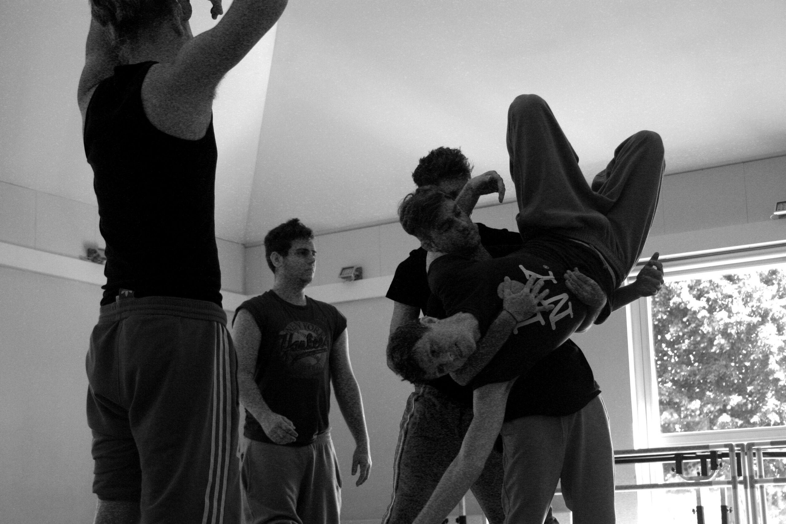 Dancers in rehearsal lift each other