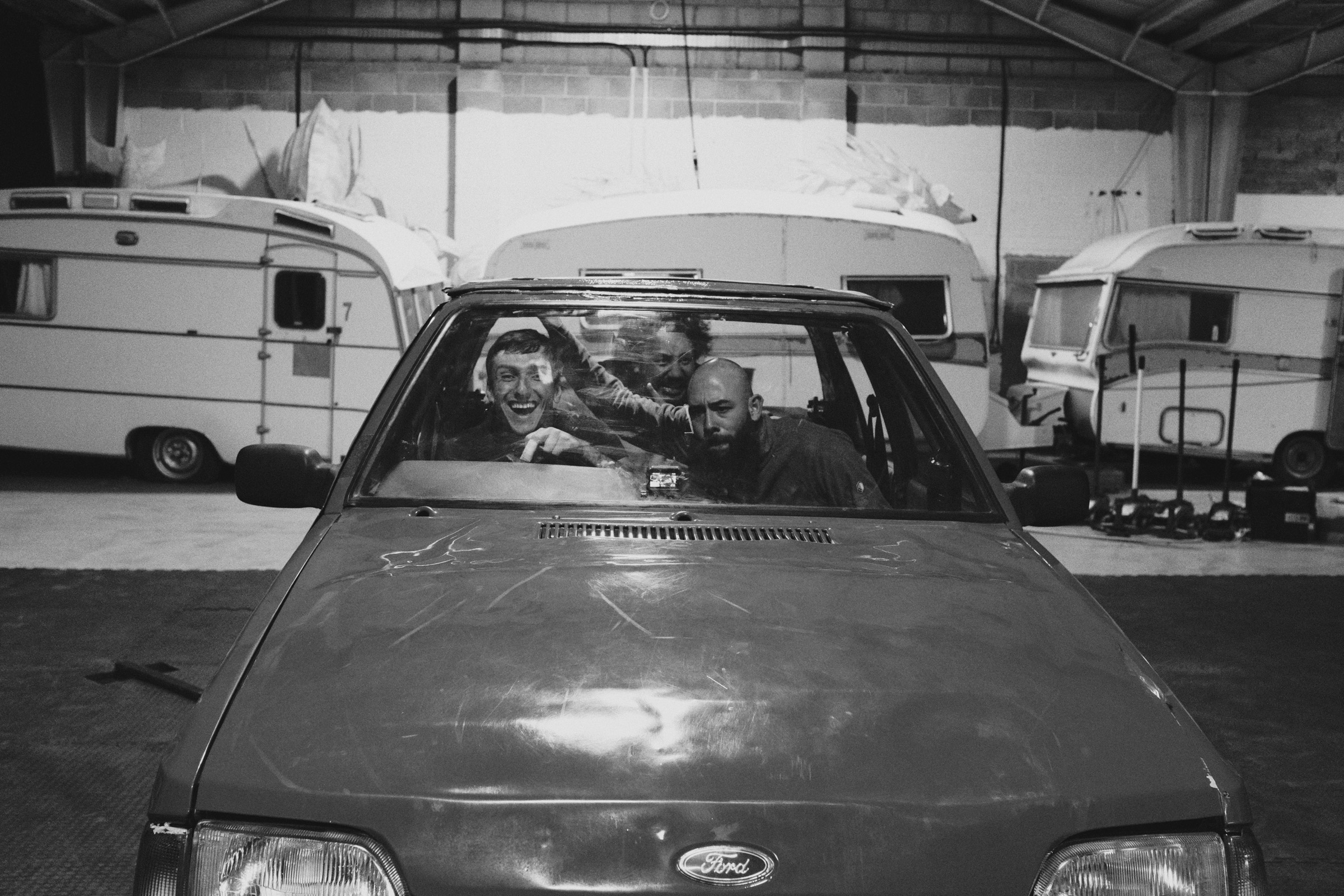 Three dancers rehearsing inside a car