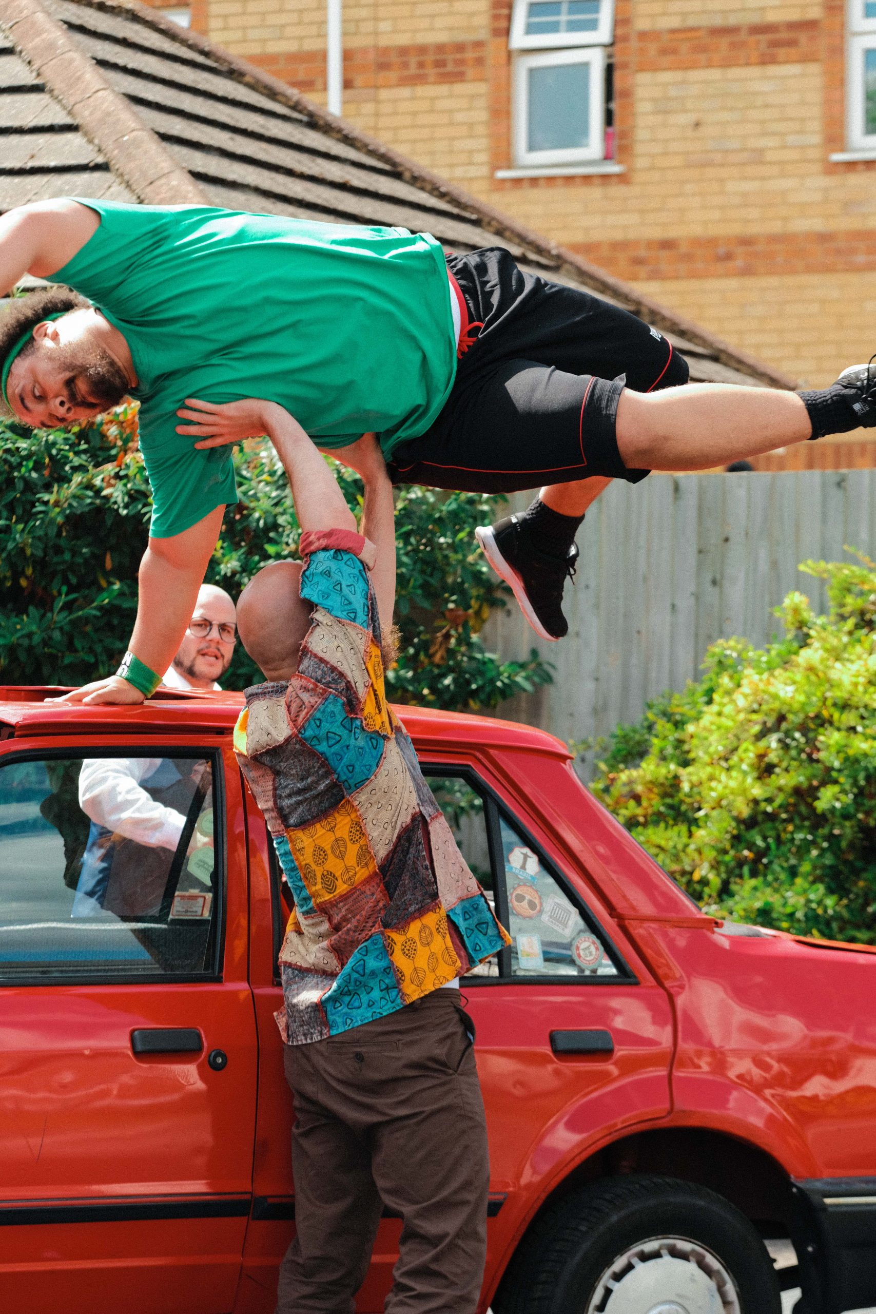 Dancer jumps off the top of a car