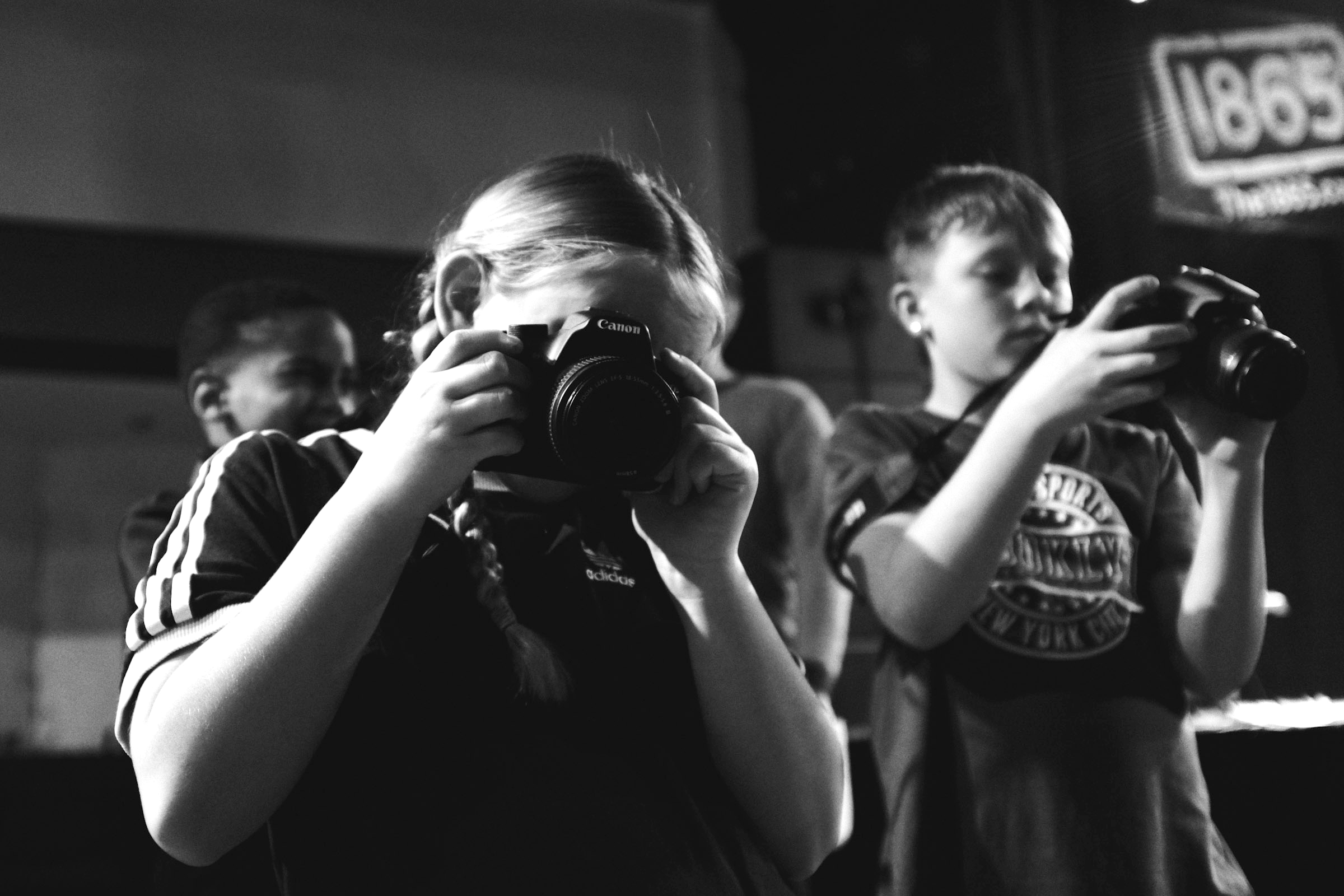 A young person aims her camera at the photographer